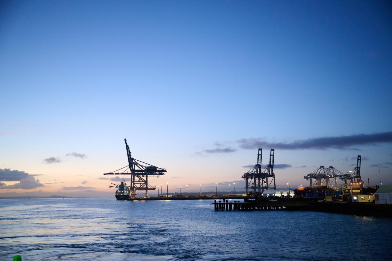 Port of Auckland container cranes from the harbour at sunrise