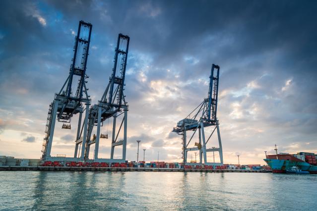 Port of Auckland container cranes at dawn from the water