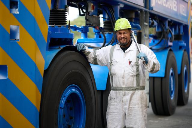 Port of Auckland worker next to a large crane wheel